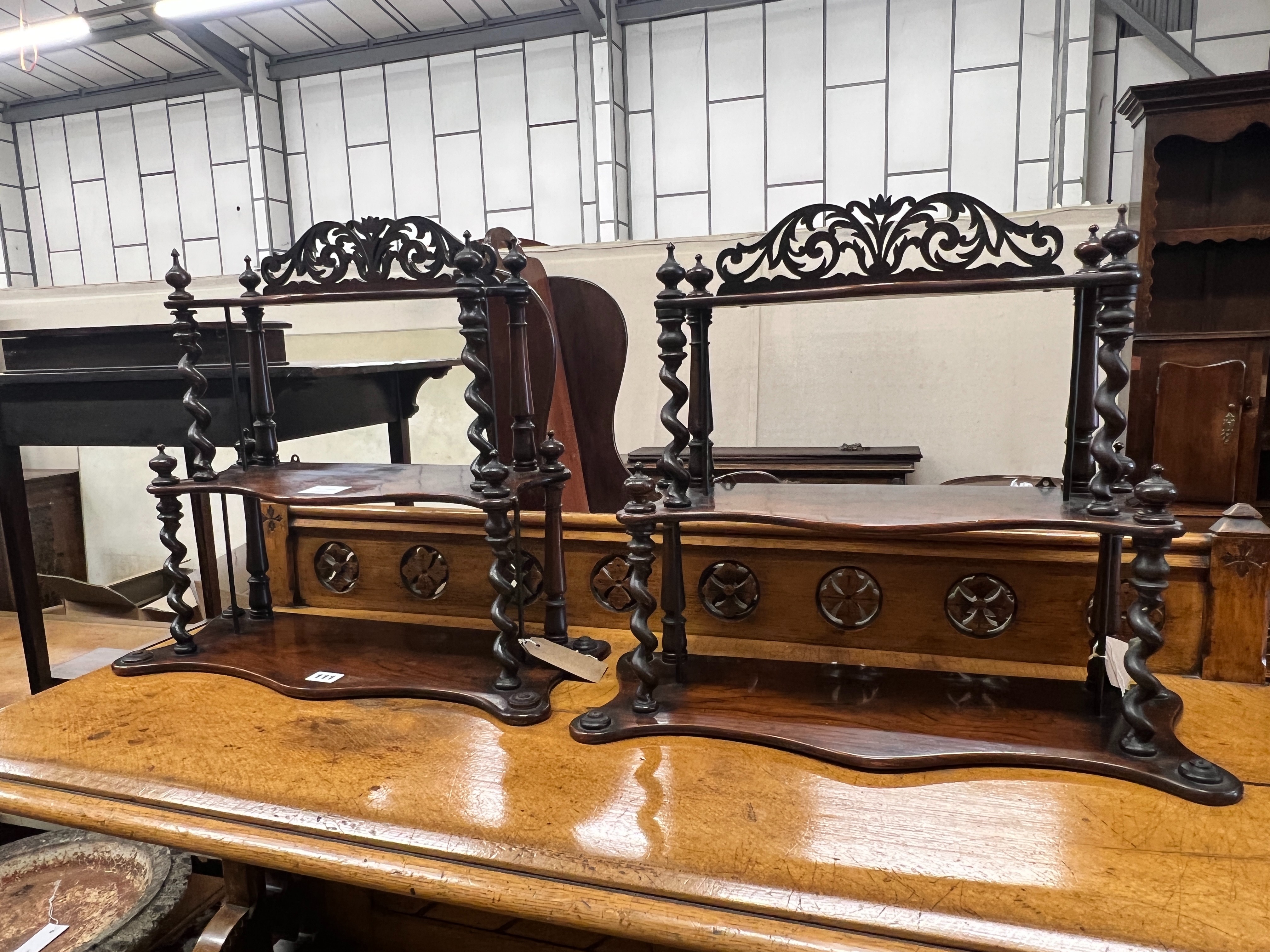 A pair of Victorian rosewood serpentine three tier wall brackets, (altered), width 50cm, depth 20cm, height 46cm